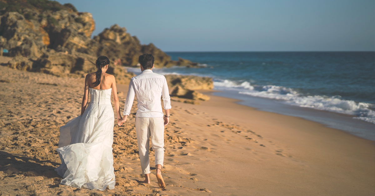 recien casados paseando playa